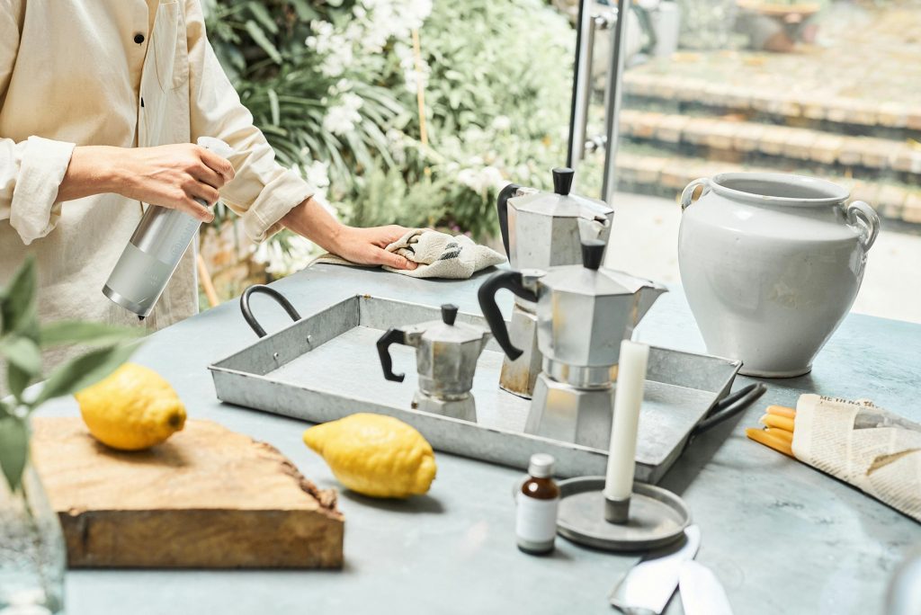 Amber spray bottle and natural cleaning ingredients on a wooden table.