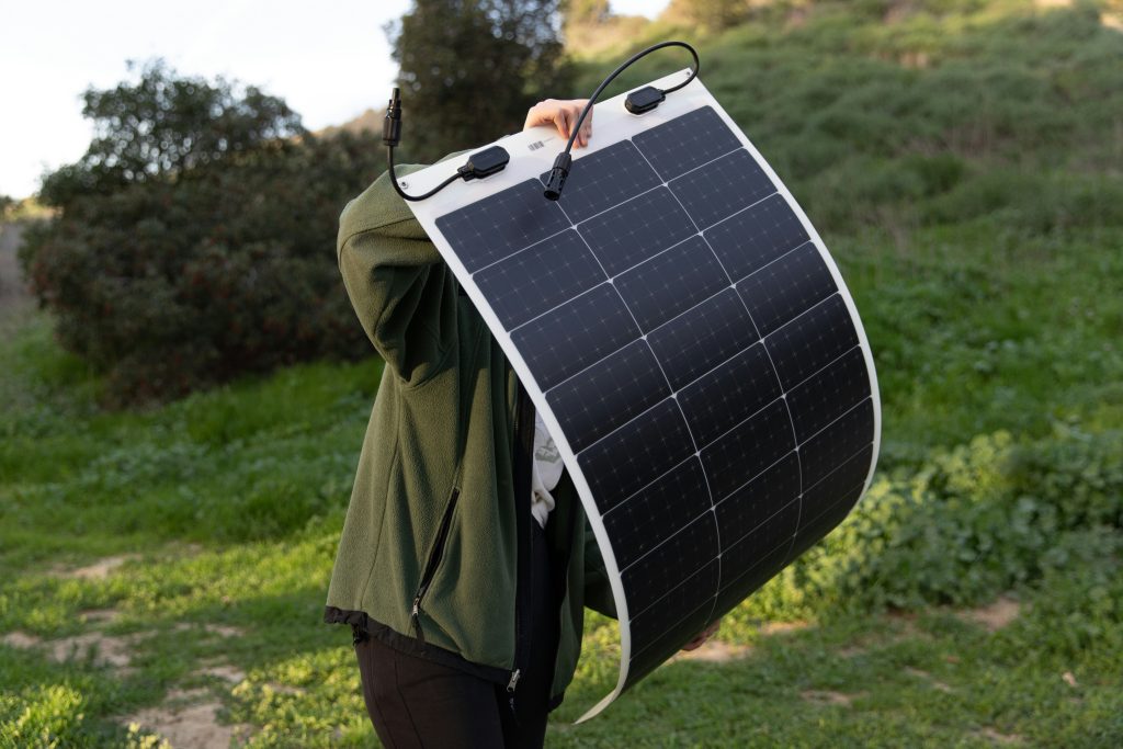 Eco travel backpack with a reusable bottle beside a portable solar charger